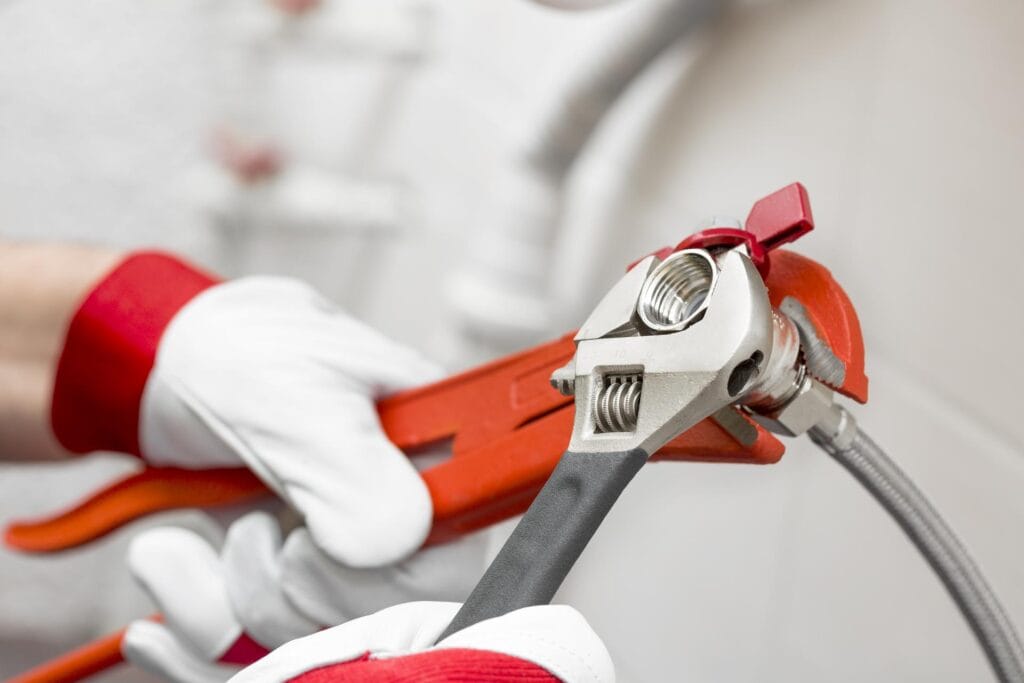 Plumber holding pipe wrenches for an emergency repair in Zephyrhills
