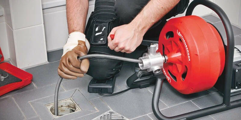 Plumber using a drain-cleaning machine in Zephyrhills